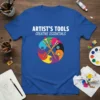 Artist's Tools Creative Essentials text with colorful paintbrushes in a circular Yin Yang design on a blue t-shirt