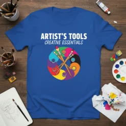 Artist's Tools Creative Essentials text with colorful paintbrushes in a circular Yin Yang design on a blue t-shirt