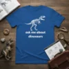Blue t-shirt with white text "ask me about dinosaurs" and a white T-Rex skeleton graphic