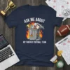 T-shirt with white text "Ask Me About My Fantasy Football Team" above a burning trash can filled with trophies, footballs