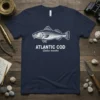Illustration of an Atlantic Cod fish with text "ATLANTIC COD Gadus mourha" on a navy blue t-shirt