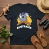 Australia Koala Boomerang T-Shirt featuring a cartoon koala pointing with an Australian flag hat and boomerang, with the word AUSTRALIA