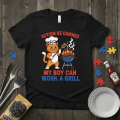 Black t-shirt featuring text "AUTISM BE DAMNED MY BOY CAN WORK A GRILL" with a cat chef grilling food