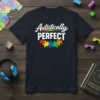 Autistically PERFECT text with colorful puzzle pieces graphic on a dark navy t-shirt, representing autism awareness and pride