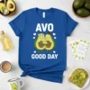 Blue t-shirt with "AVO GOOD DAY" text above a cute cartoon avocado couple hugging a heart, with small hearts around