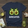 Avocatos t-shirt design with two cute avocado cats with green stripes and brown pits, text below reads AVOCATOS