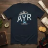 Navy t-shirt with "AYR SCOTLAND" in distressed white and blue lettering, featuring a Scottish flag and silhouette graphic