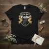 Black t-shirt with gold and white "B is for Babe" crest design, featuring a profile of a woman's head