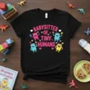 Black t-shirt with pink text "Babysitter of Tiny Humans" and cartoon characters holding blocks