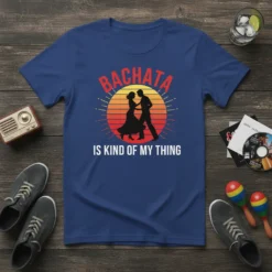 Bachata Is Kind Of My Thing text with silhouette of dancing couple and retro sunset graphic on a blue t-shirt