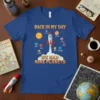 Blue t-shirt with "Back in My Day We Had Nine Planets" text and a rocket launching past planets