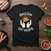Bacon Of Hope text with a sun graphic and hands holding bacon on a black t-shirt