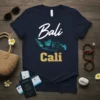 Navy blue t-shirt with "Bali Cali" text and a map graphic of Indonesia and ocean waves