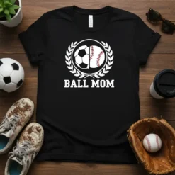 Black t-shirt with white "BALL MOM" text and a circular graphic featuring half a soccer ball and half a baseball