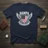BAMPA AMERICAN ORIGINAL text with wings and US flag shield graphic on a navy blue t-shirt