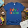 Blue t-shirt with "BE KIND" text and colorful ASL hand signs in red, orange, green, and purple