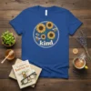 Blue t-shirt with a circular design featuring sunflowers, bees, and the word "kind" in white text