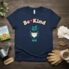 Be Kind t-shirt with a heart symbol and a plant growing in hands design