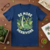 Navy t-shirt with "Be More Herbivore" text and a cartoon dinosaur surrounded by green leaves