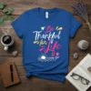 Be Thankful for Life quote in playful typography on a royal blue t-shirt, featuring a sunrise graphic