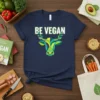 Navy blue t-shirt with "BE VEGAN" text and a stylized cow head graphic with green leaves