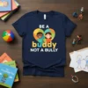 Navy t-shirt with white text "BE A buddy NOT A BULLY" and a colorful puzzle heart graphic featuring two smiling
