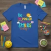 T-shirt with colorful text "Be the reason someone smiles today" featuring a sun and rainbow graphic