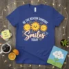 Be The Reason Someone Smiles Today t-shirt with three smiling suns graphic and cheerful typography