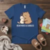 Bear Hugs & Cuddles text with a cute bear hugging a cat graphic on a navy blue t-shirt