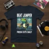 Beat Jumper Fresh Cuts Daily T-Shirt featuring a green frog DJ wearing headphones and a jacket, mixing on a turntable