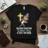 Black t-shirt with glowing yellow cross and text "BECAUSE ADULTING Without Jesus IS JUST TOO HARD", featuring a person carrying