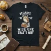 Wise owl wearing graduation cap on books with text "Because I'm The Wise One That's Why" on a black t-shirt
