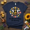 Bee Kind, Be Happy, Bee Blooming quote with a cute bee and flowers graphic on a navy t-shirt
