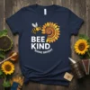 Bee Kind Shine Bright quote with a bee and sunflower graphic on a navy t-shirt