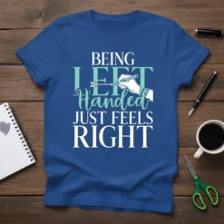 Being Left Handed Just Feels Right quote on a blue t-shirt, featuring a hand writing with a pen
