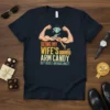 Being My Wife's Arm Candy But Here I Am Nailing It text on a navy t-shirt with cartoon biceps, diamond
