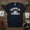 Navy t-shirt with white text "BELIEVE IN YOURSELF" and a sun graphic, motivational quote design