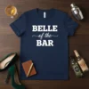 Navy blue t-shirt with white text "BELLE of the BAR" in bold and script fonts, designed for party queens
