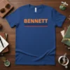Blue t-shirt with bold orange "BENNETT" text and retro navy and red stripes underneath