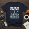 Navy blue t-shirt with white and light blue "BERLIN CALLING" text and a minimalist Berlin cityscape graphic