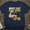 Best Cat Dat Dad Ever t-shirt with a muscular arm holding a black cat and bold yellow text