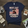 Navy t-shirt with "BEST CAT GRANDPA EVER" text, sunglasses-wearing black cat, and American flag graphic with paw prints