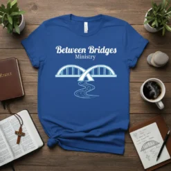 Blue t-shirt with "Between Bridges Ministry" text and a graphic of two bridges over a river