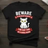 Black t-shirt with text "Beware of the dog but beware of the cat too he's kinda weird" and a grumpy