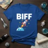 BIFF text above a cartoon rocket ship launching from the moon, surrounded by stars, on a blue t-shirt
