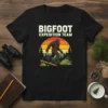 Bigfoot Expedition Team t-shirt design featuring a walking Bigfoot silhouette against a retro sunset and forest background