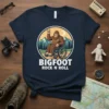 Bigfoot sitting in a wheelchair with a rock on hand gesture, text reads BIGFOOT ROCK N ROLL, set against a