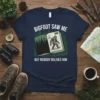 Bigfoot Saw Me But Nobody Believes Him quote on a navy blue t-shirt with a Bigfoot illustration in an open