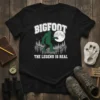 Bigfoot The Legend Is Real T-Shirt featuring a green Bigfoot silhouette against a moonlit forest scene