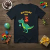 Birthday Boy 3 T-Shirt with a green cartoon Tyrannosaurus Rex wearing a party hat and holding a balloon